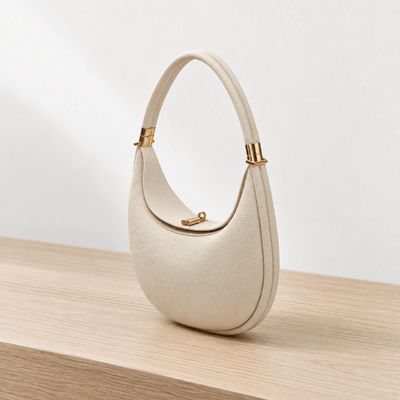 The Sunday Avenue Celeste Cream Pebbled Leather Crescent Shoulder Bag
